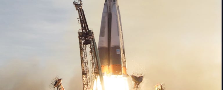 A rocket launching into the sky with flames and smoke billowing from its engines, supported by launch structures.